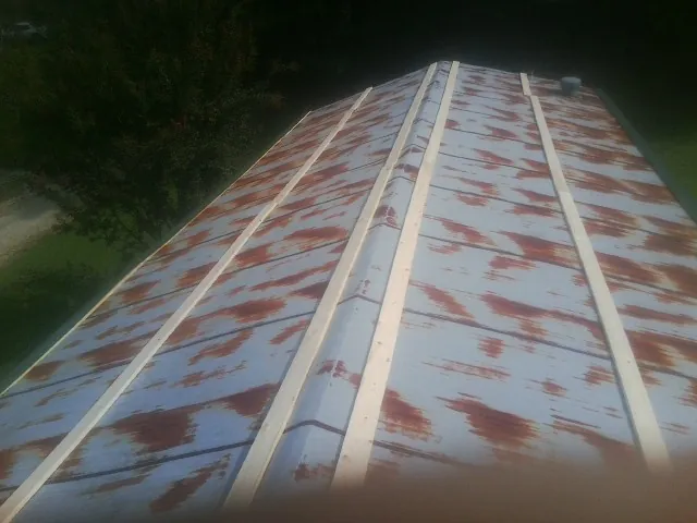 Rusted metal roof panels with new wood purlins before replacement — Storm Damage Roof Repair in Kittrell by Roofing Brothers